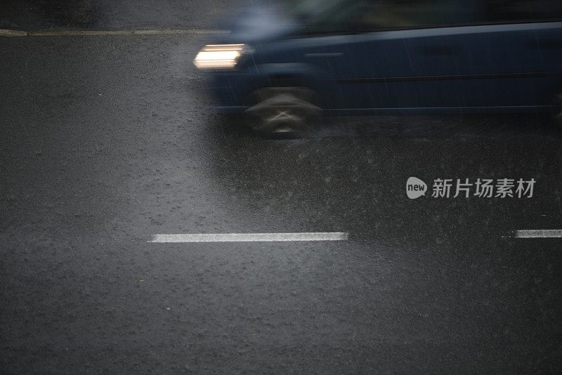 倾盆大雨时汽车在路上行驶