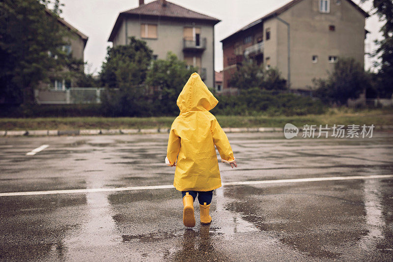 小男孩在阴雨的秋日在户外散步