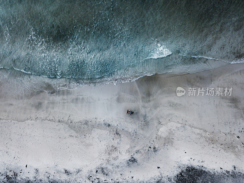 挪威罗浮敦群岛克瓦尔维卡海滩上遛狗的夫妇鸟瞰图