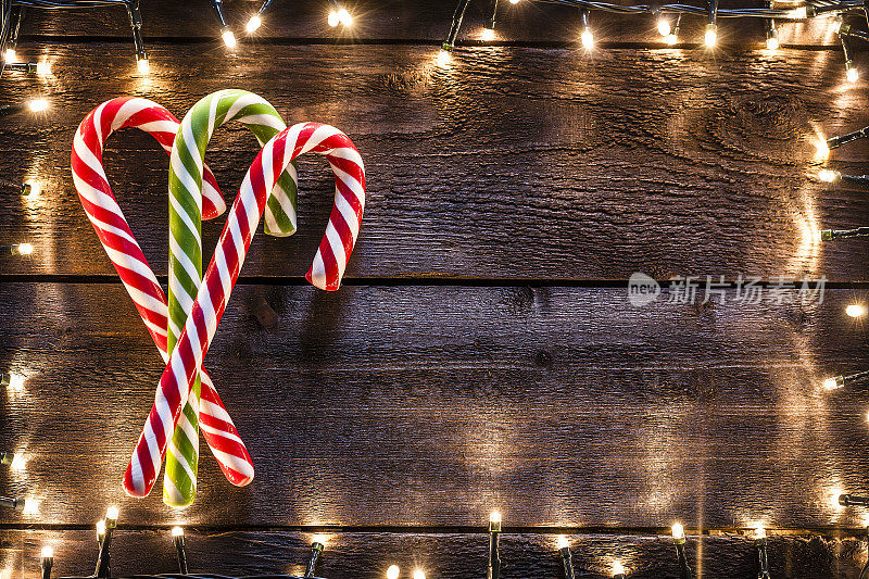 圣诞背景:质朴的木桌上放着三根拐杖糖