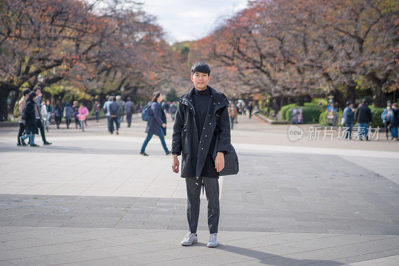 年轻的亚洲男子和日本朋友寻找旅游地点使用手机和花时间在亚洲旅行