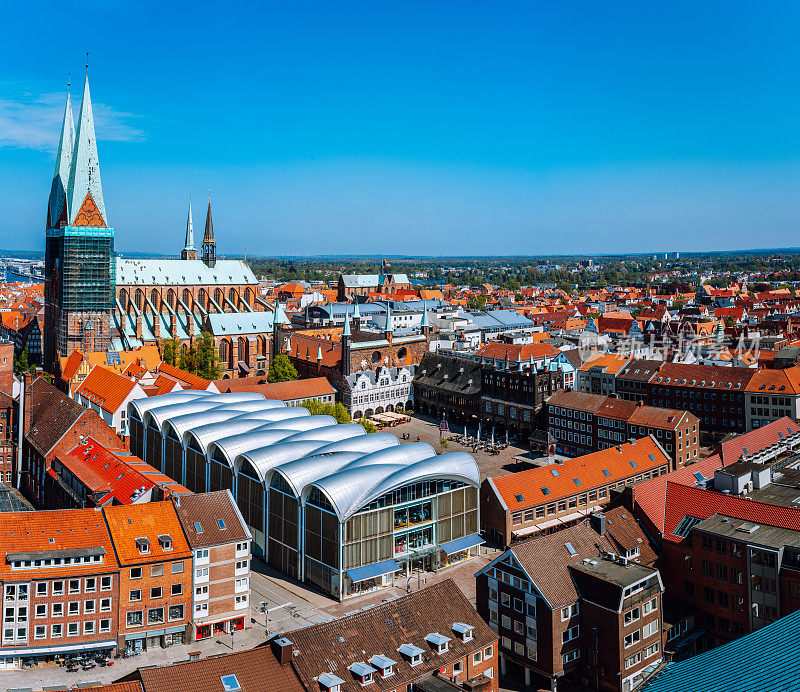德国北部石勒苏益格-荷尔斯泰因州吕贝克市场的鸟瞰图，周围是教堂尖塔和古老的城市砖房和瓦片屋顶