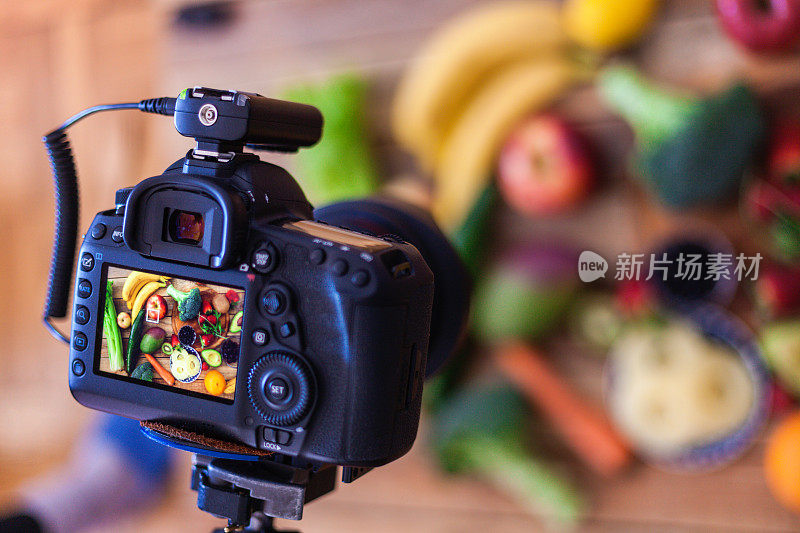 用单反相机拍摄木桌上各种各样的水果和蔬菜