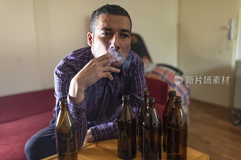 年轻悲伤的醉酒男子喝啤酒和酒精感到浪费，孤独和绝望的痛苦和情绪压力。人与酗酒、上瘾和男人抑郁的概念。