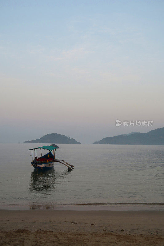 图片中的游船停泊在果阿海岸，准备清晨日出海豚观察巡航，果阿海滩，印度