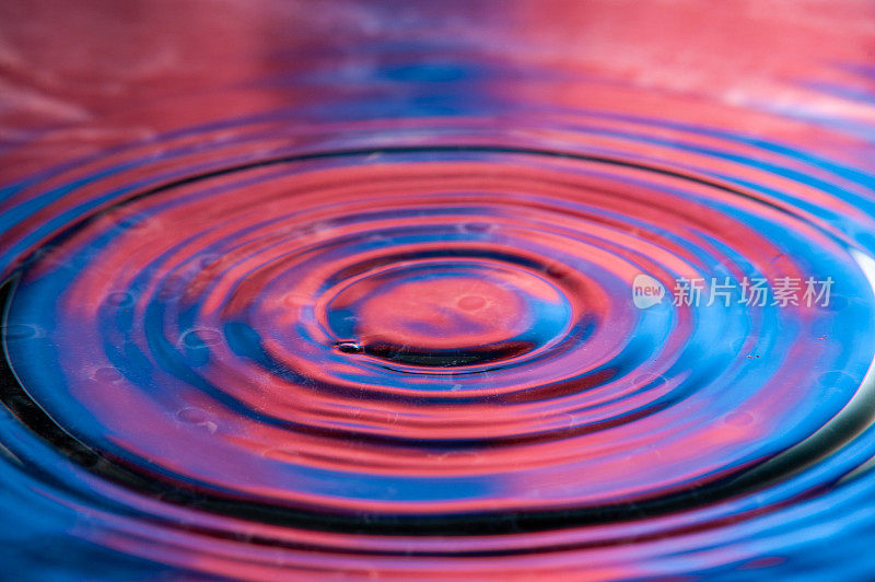 充满活力的红色和蓝色圆形涟漪。高速水滴摄影