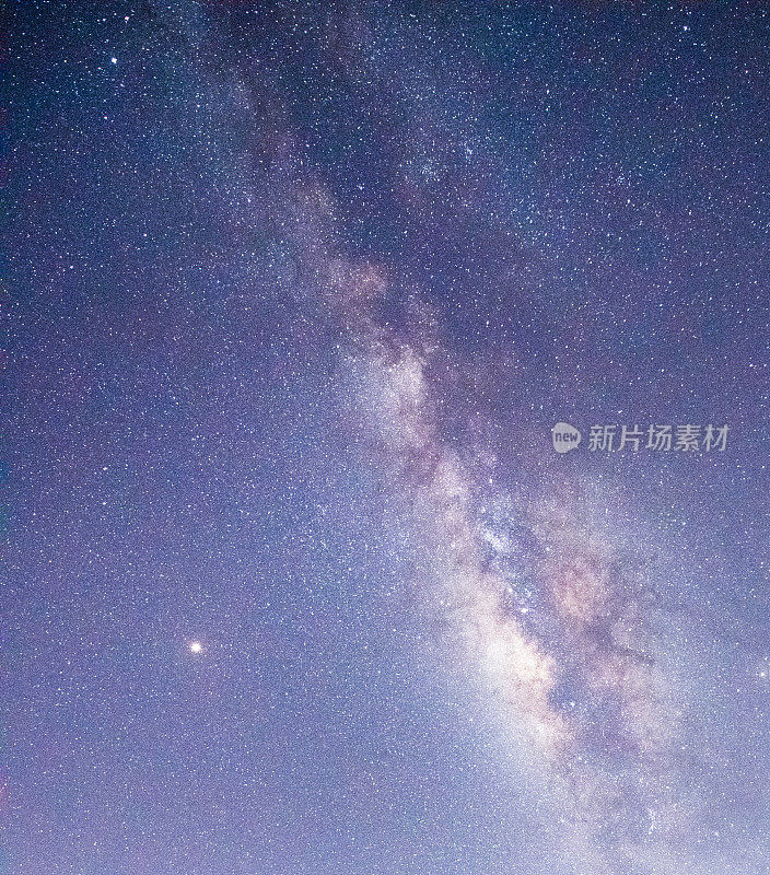 山上有银河和粉红的光。晚上多彩的景观。夏天的星空和山峦。美丽的宇宙。太空背景与星系。旅游的背景