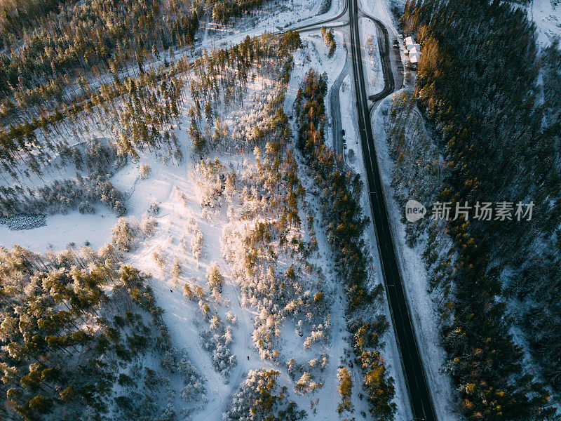 鸟瞰图的道路和森林在冬天的时间。来自空气的自然冬季景观。芬兰的风景从无人机