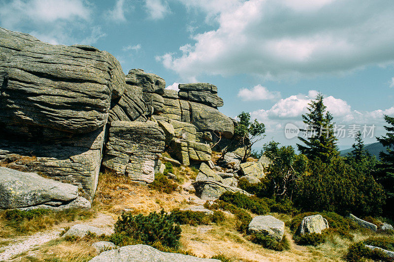 形状奇特的岩石，背景是山脉