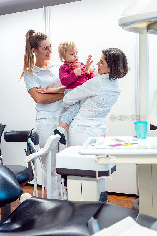 牙医和她的助手带着孩子在办公室里