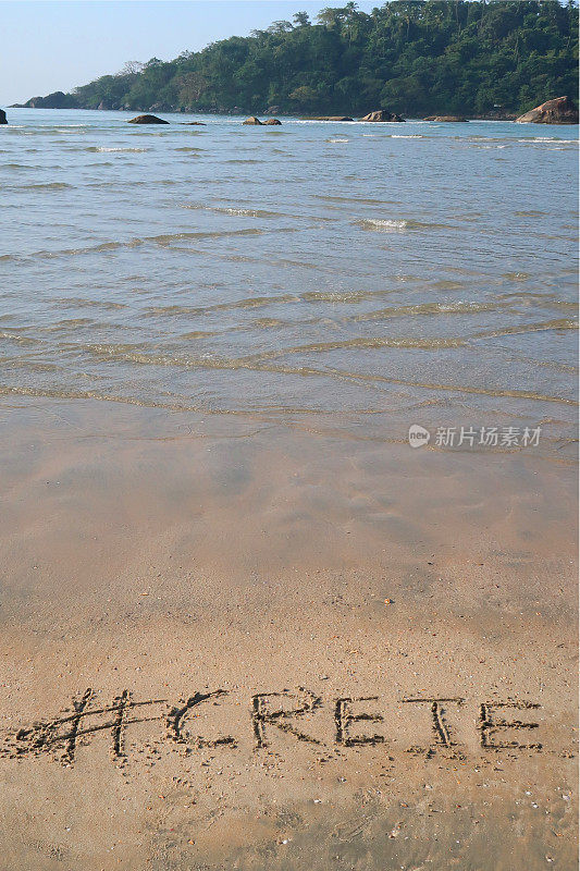 图片的标签标签写在阳光明媚的海滩克里特岛，希腊单词写在海边的沙子，帕洛伦海滩，印度果阿，概念社交媒体照片手写在金色的沙子与现代标签前缀