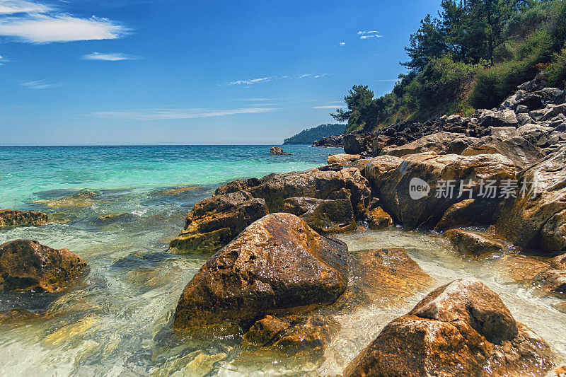 希腊岛上美丽的海滩，岩石嶙峋的海岸线，绿松石般的大海