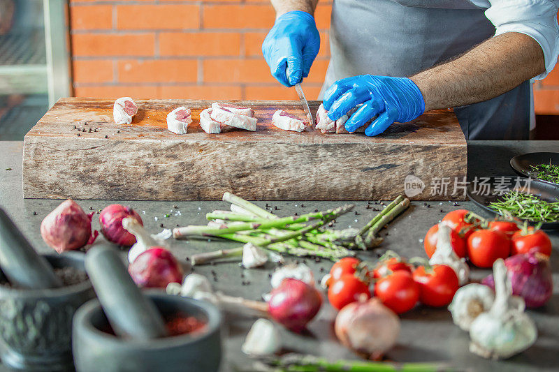 厨师长在设备齐全的酒店餐厅厨房准备腌制和调味肉