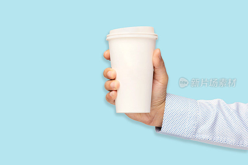 一个拿着蓝色背景的纸杯咖啡的男人