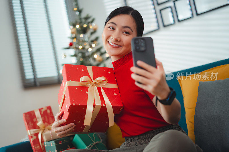 亚洲女性喜欢在圣诞节用智能手机打视频电话或直播视频视频。