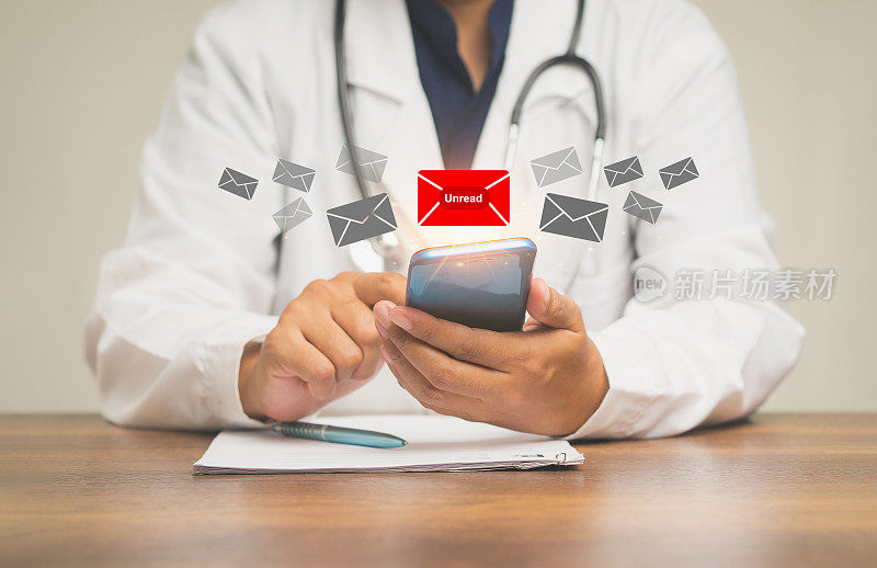 当医生坐在桌旁时，使用手机会收到一条带有未读邮件图标的新消息。