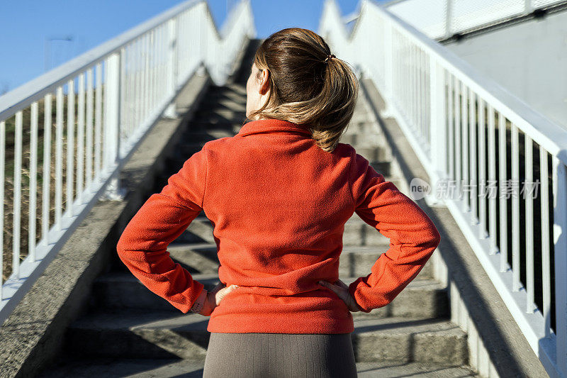 在桥上楼梯上慢跑的女运动员