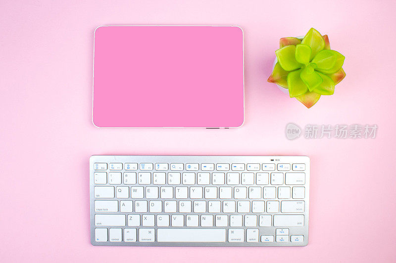 粉红色的办公桌子上有电脑，钢笔和一杯咖啡，很多东西。带复制空间的俯视图。
