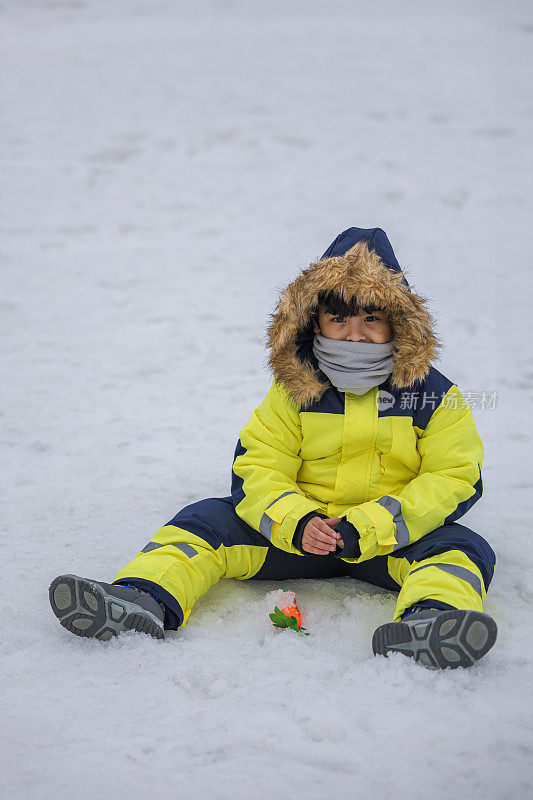 孩子们在雪中玩耍。冬天，穿着滑雪服的亚洲孩子在扔雪。快乐的童年。江原道，韩国