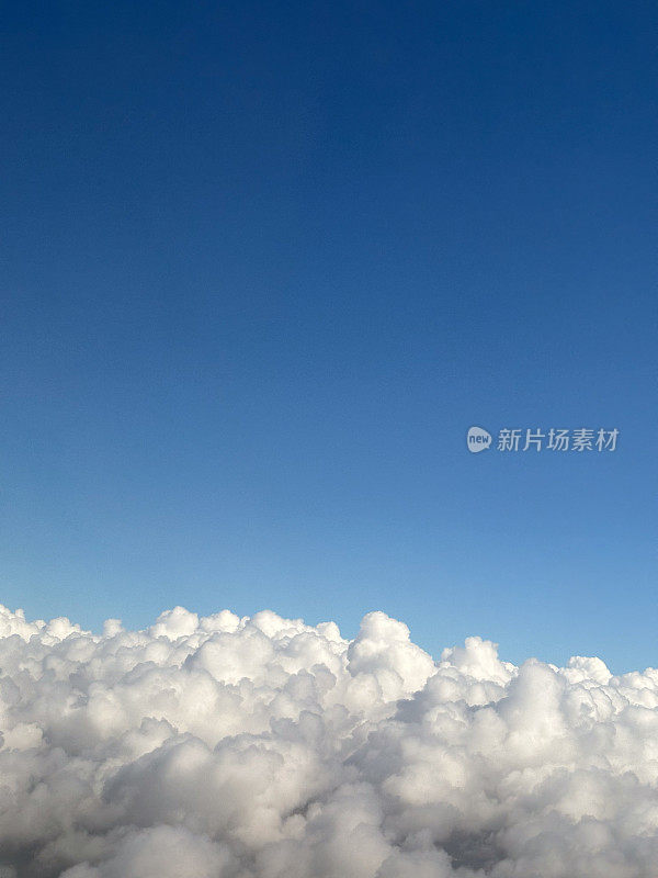 从高空的飞机窗口可以看到白云和蓝天