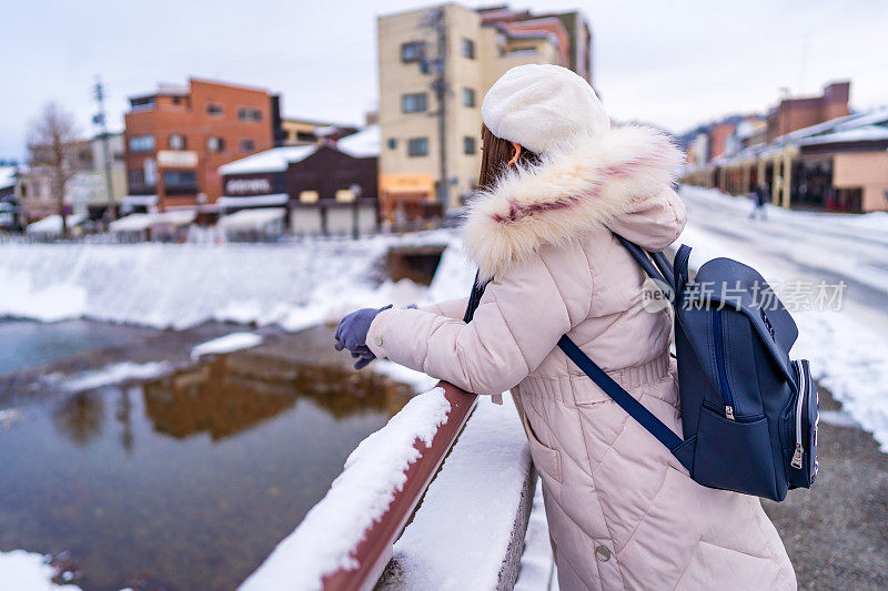 美丽的女游客享受他们的日本之旅在雪的冬天