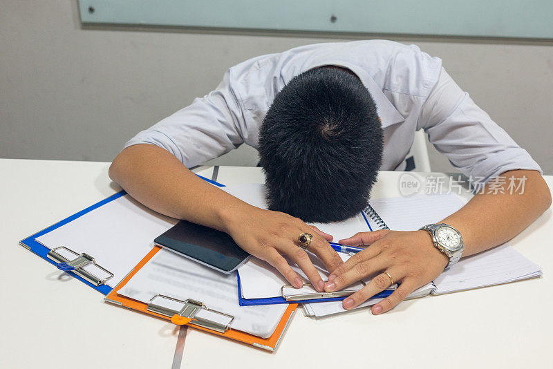 精疲力竭的男人感觉被他处理的报告缠住了