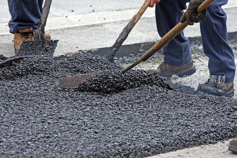 在公路维修现场铺热沥青