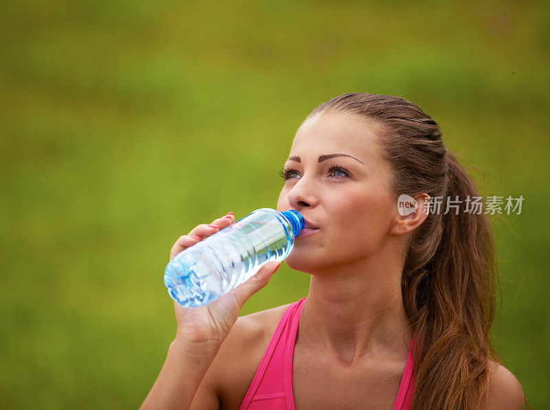 喝瓶子里水的女人