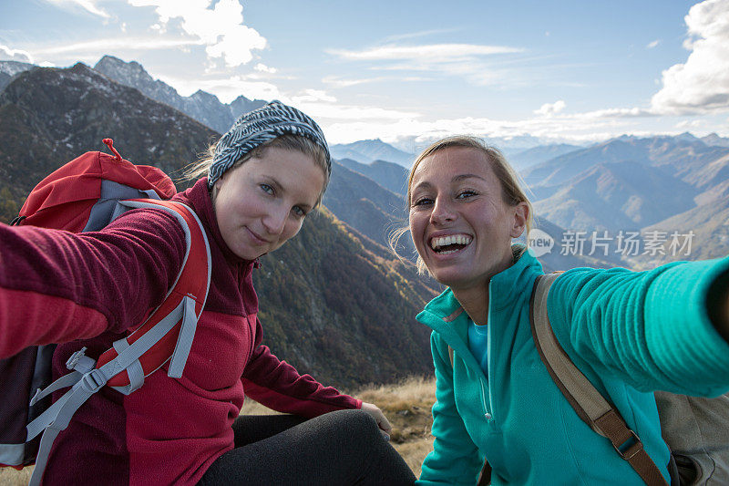 两个徒步旅行的年轻女子在山顶自拍