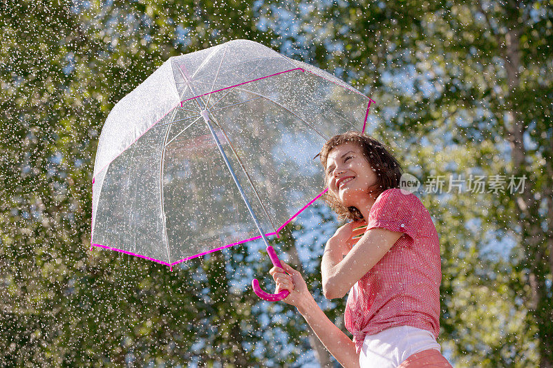 顽皮的年轻女子撑着伞