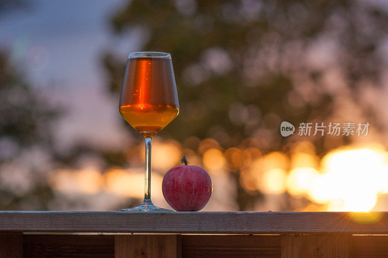 一杯苹果酒配上夕阳下的苹果