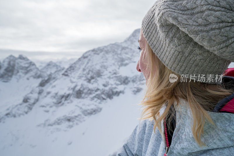 年轻女子在滑雪坡上看风景