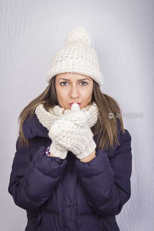 漂亮的年轻女子穿着冬衣暖手