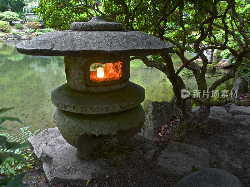 石头灯笼蜡烛辉光池塘背景波特兰日本花园俄勒冈