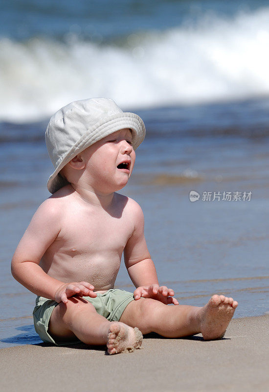 男孩在沙滩上哭泣