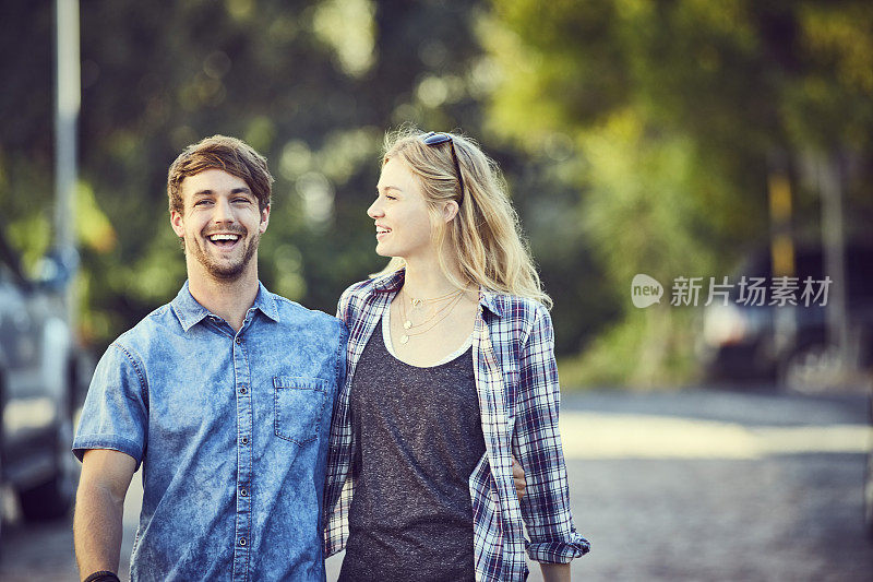 一对相爱的年轻夫妇走在城市的街道上