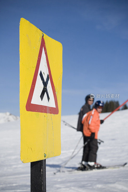 在滑雪缆车上有两个路过的滑雪者的十字标志