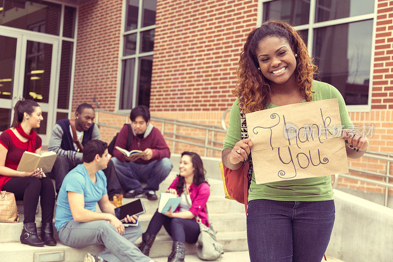 教育背景:非洲裔大学生举着“谢谢”的牌子。