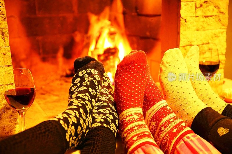 一家人穿着羊毛袜子在壁炉前取暖