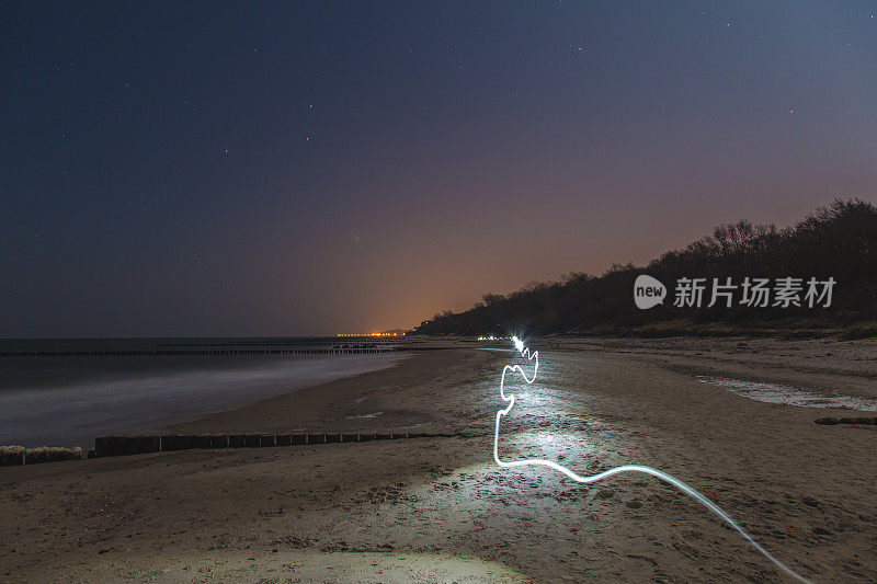 夜晚海滩上未来的灯光轨迹