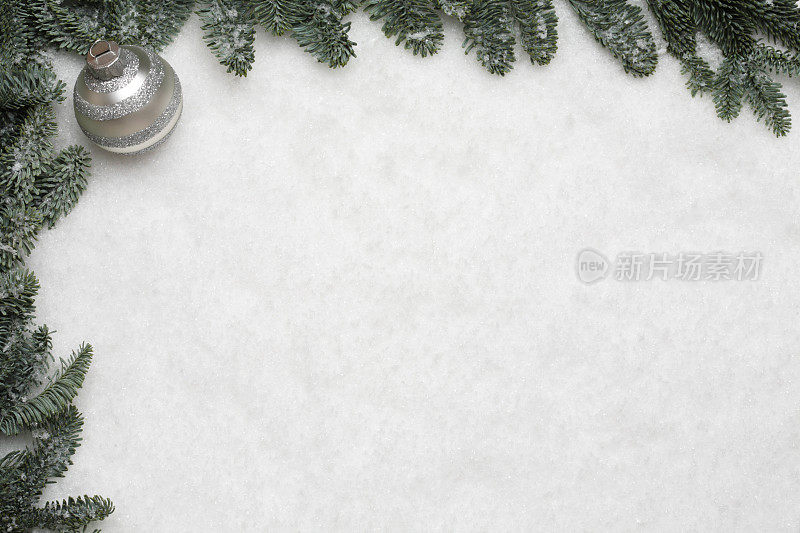 松树框架与圣诞小玩意在雪的背景