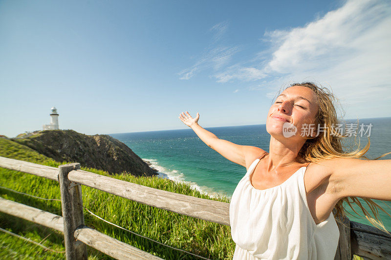 一个白人女人在拜伦角张开双臂