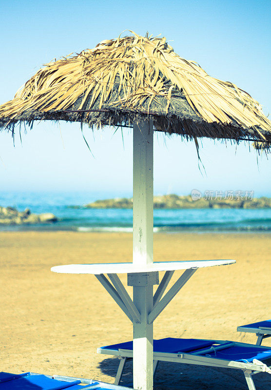 茅草沙滩伞，金色沙滩和大海在黎明