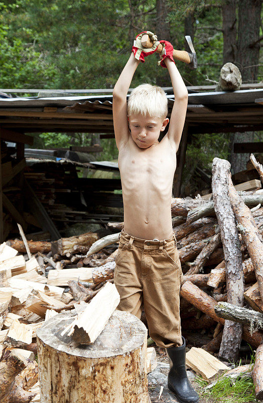 小男孩在专心地砍柴。