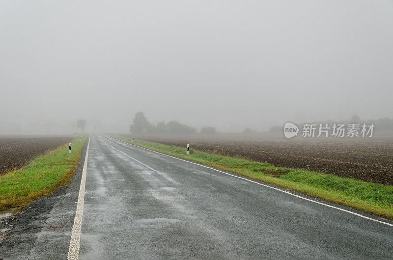 乡村街道上的早晨，雾气蒙蒙，下着雨——十一月的坏天气