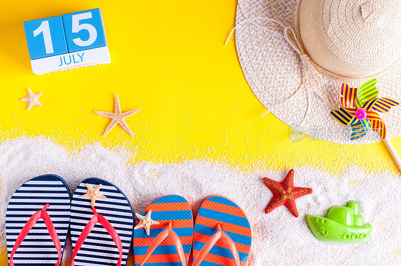 7月15日。7月15日的日历图片与夏季海滩配件和旅行者的服装背景。夏日，度假概念