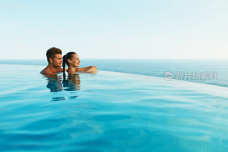 情侣在豪华度假胜地游泳池浪漫的暑假