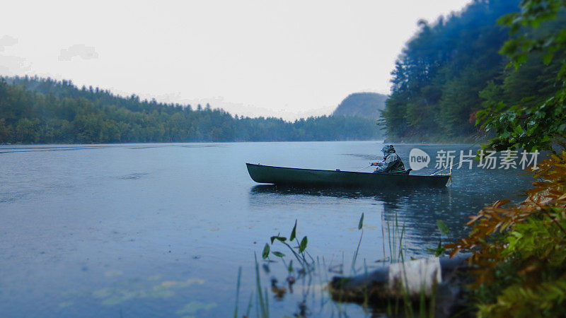 人独木舟在雨中钓鱼，鹤池，阿迪朗达克山脉，纽约