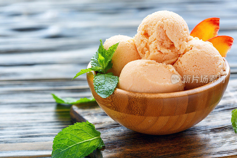 球桃子冰淇淋在一个木碗。