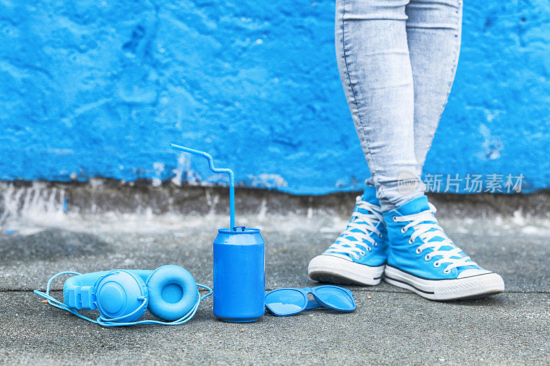 蓝色耳机，蓝色罐子和太阳镜靠在地上